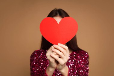 Sevgililer Günü. Bej arka planda kağıt kalpli güzel bir kadın.