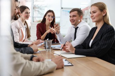 İş adamlarından oluşan bir ekip ofiste birlikte çalışıyor.