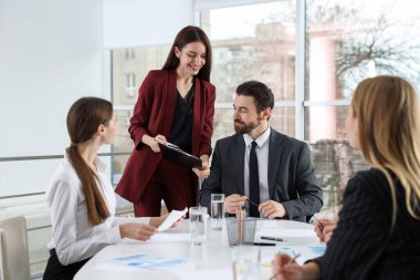 İş adamlarından oluşan bir ekip ofiste birlikte çalışıyor.