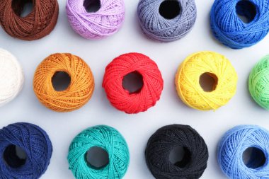 Beyaz arka planda farklı iplikçiklerin topları, düz yatış