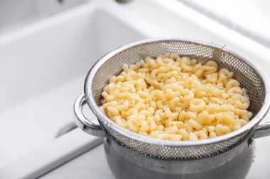 Mutfakta makarna üzerine elek, yakın plan. Metin için boşluk