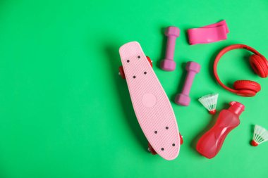 Tahta, su şişesi, dambıl, mekik horozu ve kulaklık yeşil arka planda, düz konum. Metin için boşluk