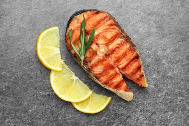 Lezzetli ızgara somon bifteği, limon ve biberiyeyle servis edilir.