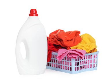 Çamaşır sepetinin içinde giysiler ve beyaza izole edilmiş bir şişe deterjan.