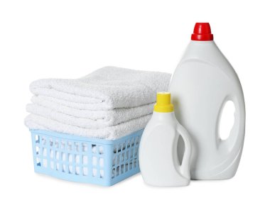 Çamaşır sepeti, yumuşak havlular ve beyaza izole edilmiş deterjan şişeleri.