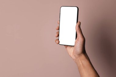 Dusty Rose arka planında boş ekranlı akıllı telefon tutan adam, yakın plan. Tasarım için model