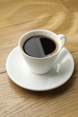 Ahşap masada, fincanda Aromatik kahve, yakın plan.