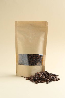Bej arkaplanlı kahve çekirdekli stand-up kesesi.