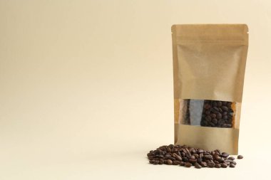 Bej arka planda kahve çekirdekli stand-up kesesi, metin için boşluk