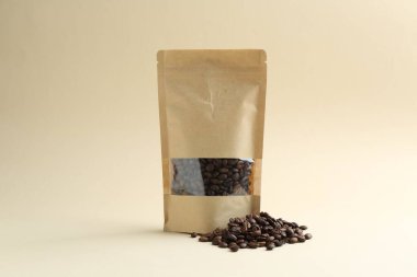 Bej arkaplanlı kahve çekirdekli stand-up kesesi.