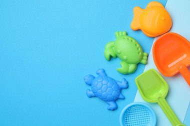 Açık mavi arka planda çocukların plaj oyuncakları, düz yatış. Metin için boşluk