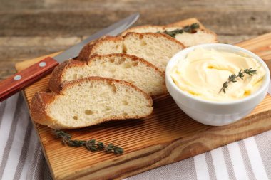 Tereyağlı baget dilimleri, kekik ve bıçak masada, yakın plan.