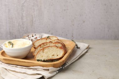 Gri desenli masada tereyağlı ve baharatlı baget dilimleri, yakın plan. Metin için boşluk