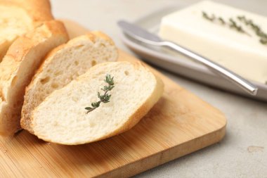 Gri masada tereyağlı baget, kekik ve bıçak kes, yakın plan.