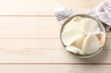 Kavanozda kırmızı biber ve açık ahşap masa üzerinde peçete olan lezzetli pirinç kağıdı cipsleri. Metin için boşluk