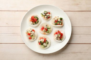 Sebzeli lezzetli pirinç kağıdı cipsi, beyaz peynir ve siyah susam tohumları açık ahşap masa, üst manzara