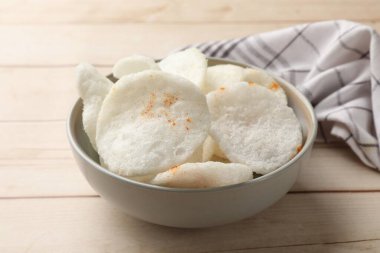 Kavanozda kırmızı biber ve açık ahşap masada peçete, yakın plan.