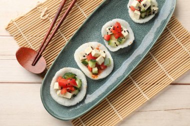 Sebzeli lezzetli pirinç kağıdı cipsi, beyaz peynir ve siyah susam tohumları açık ahşap masa, üst manzara