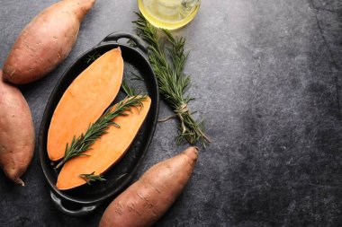 Çiğ patates, biberiye ve yağ siyah masada, düz yerde. Metin için boşluk