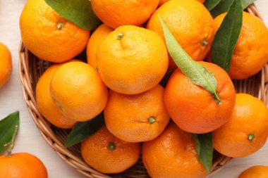 Taze mandalina ve yeşil yapraklar ışık masasının üstünde, manzaranın üstünde.