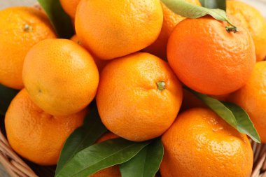 Taze mandalina ve yeşil yapraklar masada, yakın plan.