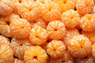 Arka plan olarak birçok olgun soyulmuş mandalina, üst görünüm