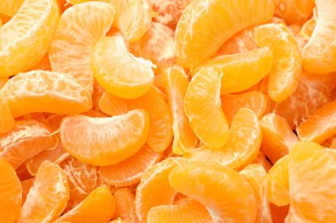 Arka plan olarak birçok olgun soyulmuş mandalina, üst görünüm