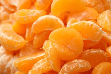 Arka plan olarak birçok olgun soyulmuş mandalina, yakın plan