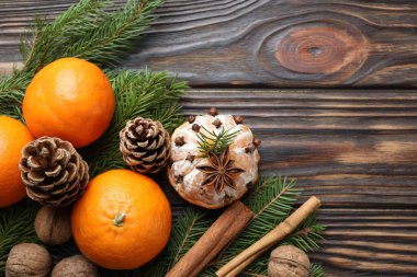 Olgun mandalinalar, baharatlar, cevizler, köknar ağacı dalları ve tahta masa üzerindeki koniler, düzlük. Metin için boşluk