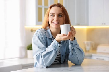 Mutfakta taze kahve içen bir kadın.