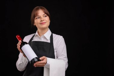 Siyah arka planda kırmızı şarap şişesi olan profesyonel şarap garsonu.