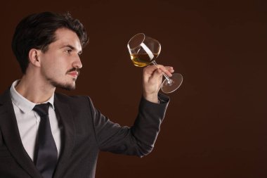 Kahverengi arka planda beyaz şarap kadehi olan profesyonel şarap garsonu. Metin için boşluk