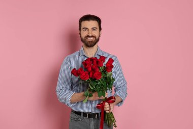 Sevgililer Günü. Pembe arka planda gül buketi olan adam.