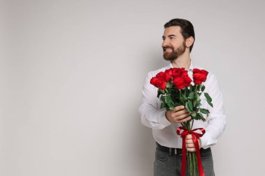 Sevgililer Günü. Hafif arka planda gül buketi olan yakışıklı bir adam. Metin için boşluk