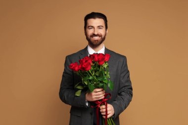 St. Valentine's Day. Man with bouquet of roses on beige background