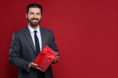 Sevgililer Günü. Kırmızı arka planda yeteneği olan yakışıklı bir adam. Metin için boşluk