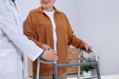 Huzurevinde Walker 'a yardım eden bakım işçisi, yakın plan.