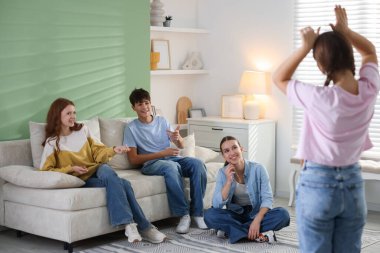 Evde sessiz sinema oynayan bir grup genç.