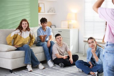 Evde sessiz sinema oynayan bir grup genç.