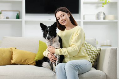 Evdeki kanepesinde Collie köpeği olan bir kadın.