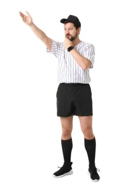 Üniformalı hakem beyaz arka planda düdük çalıyor.