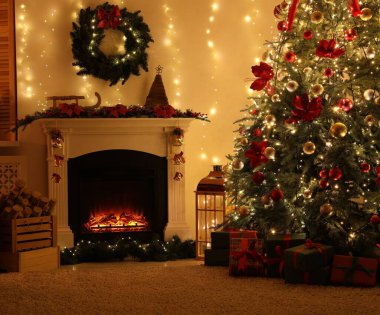 Güzel bir şömine, Noel ağacı ve karanlık odada şenlikli bir dekor. İç tasarım