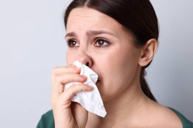 Hafif arka planda burnu akan kadın, yakın plan. Soğuk Semptom