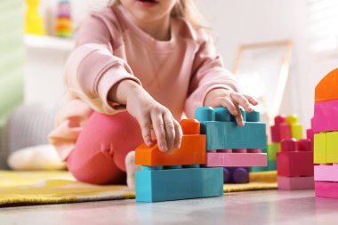 Küçük kız oyuncaklarla oynuyor oyun odasında, yakın plan.