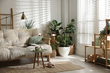 Kanepesi ve çiçekleri olan şık bir oturma odası. İç tasarım