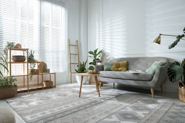 Kanepesi ve çiçekleri olan şık bir oturma odası. İç tasarım