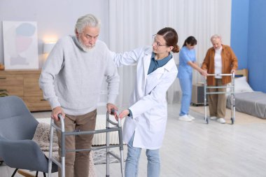 Huzurevinde aylaklara yardım eden bakım işçileri, seçici odaklanma