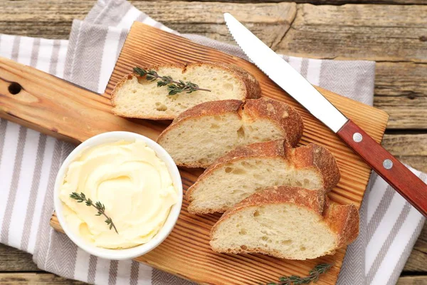 Tahta masada tereyağlı baget, kekik ve bıçak dilimleri.