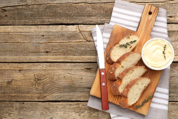 Tahta masa üzerinde tereyağlı baget, kekik ve bıçak dilimleri. Metin için boşluk