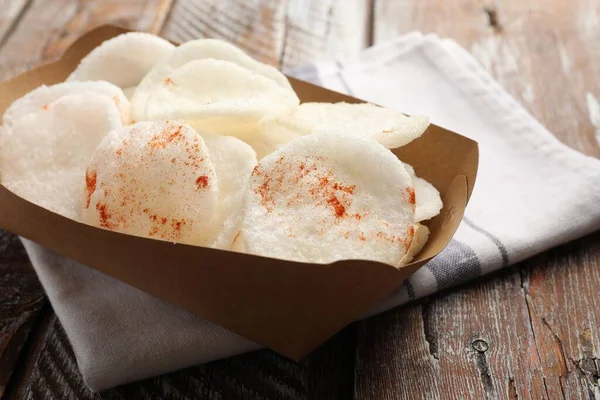 Paket içinde lezzetli pirinç kağıdı parçaları ve renkli ahşap masa üzerinde peçete, yakın plan.